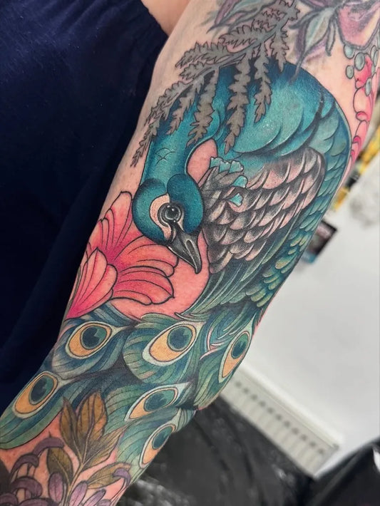 Big Color Peacock and Flowers Tattoo on Women Arm by @sophiecahilltattoo