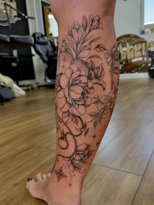 Big Fine Line Floral Snake Tattoo on Women Calf by @studio13_crawley