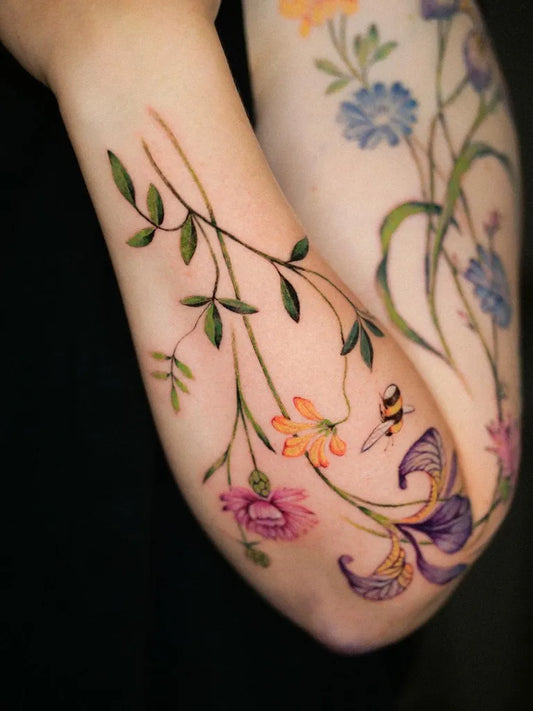 Big Floral Wildflowers with Bee and Leaves on Women Arm Flower Tattoo by @veroni.ink