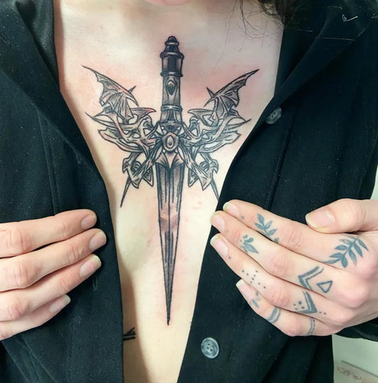 Big Gothic Dagger with Wings on Women Sternum Tattoo by @ilenadoodles