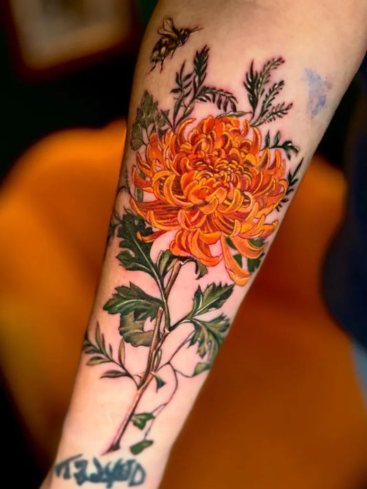 Big Illustrative Orange Chrysanthemum with Bee and Foliage Tattoo on Women Arm by @eireink