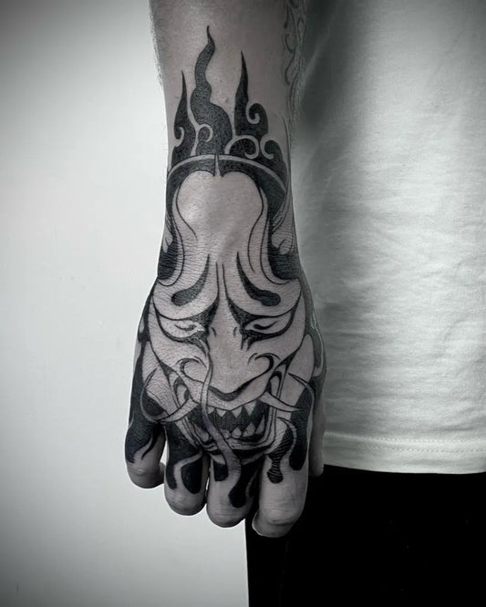 Big Japanese Oni Mask with Flames on Men Hand Tattoo by @dreamhandstattoostudio