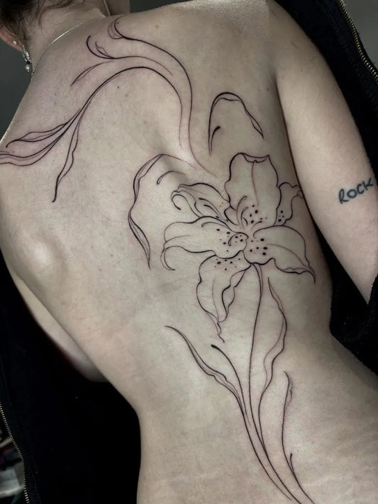 Big Linework Flowering Lily on Women Back Tattoo by @elizaplattstattoo
