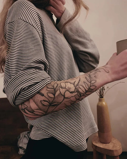 Big Negative Space Floral Leaves Tattoo on Women Arm by @lynn.ivarsson