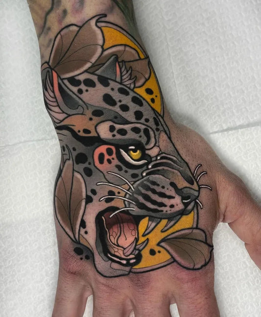 Big Neo Traditional Leopard with leaves on Men Hand Tattoo by @jj.neotraditional