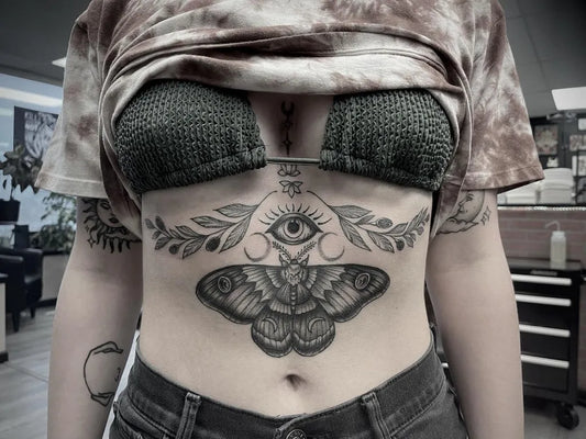 Big Neo Traditional Moth Eye Laurel on Women Sternum Tattoo by @hunnybtattoos