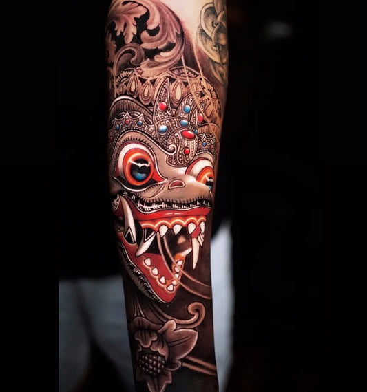 Big New School Balinese Mask with Floral Elements Tattoo on Men Arm by @yandemarlon_tattooer