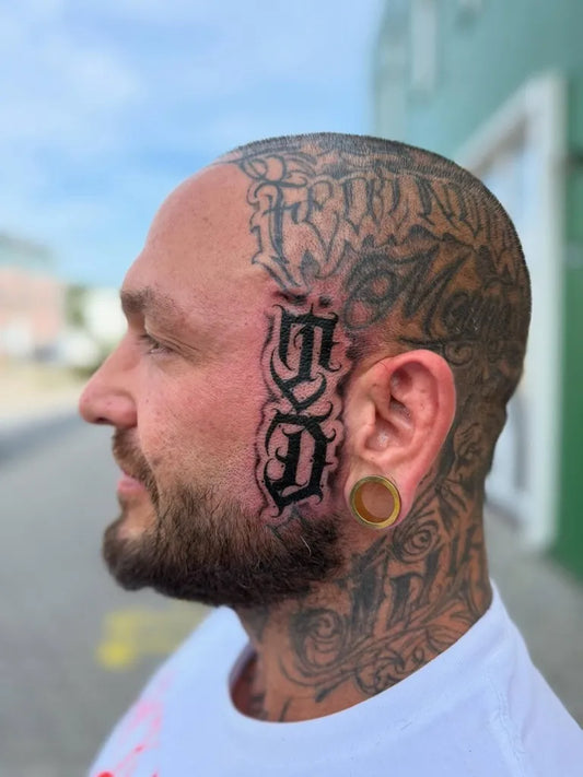 Big Old English GD on Men Face Tattoo by @rayfalixtattoo