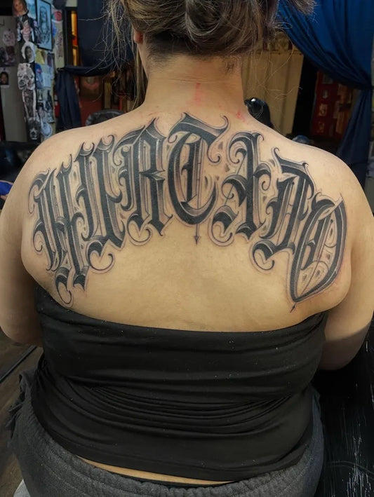 Big Old English text on Women Back Tattoo by @lonelyboytattoos