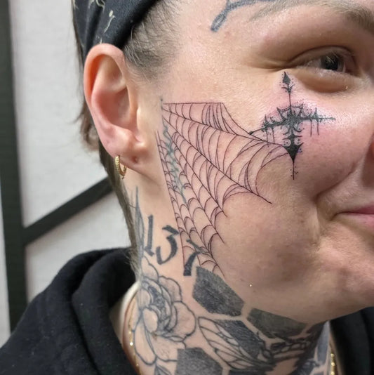 Big Prison Style Web and Cross on Women Face Tattoo by @hollie_tattoos