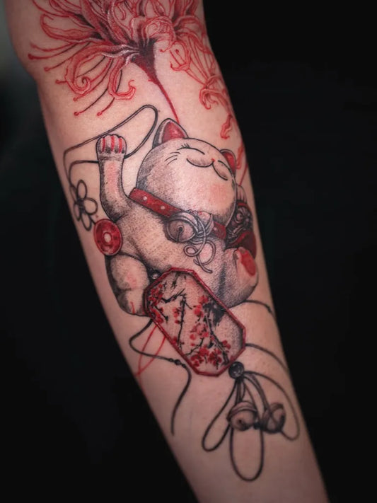 Big Red Maneki Neko with Lotus and Tassel Tattoo on Women Arm by @grantlutattoo