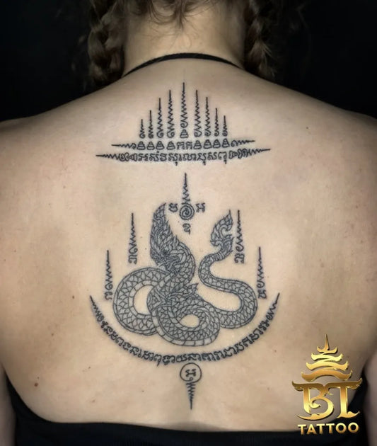 Big Sak Yant Naga Serpent with Sak Yant Script Tattoo on Women Back by @bttattoobangkokthailand