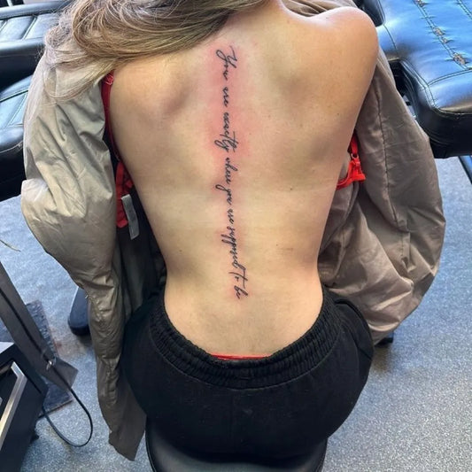 Big Script Text on Women Spine Tattoo by @oldempiretattoo