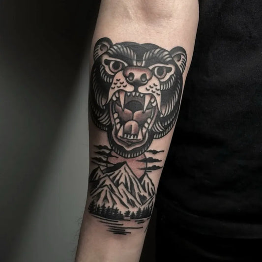 Big Traditional Bear with Mountains on Men Arm Tattoo by @sthlmclassictattoo
