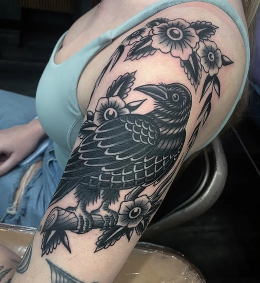 Big Traditional Raven and Flowers on Women Arm Tattoo by @lindseycvtattoo