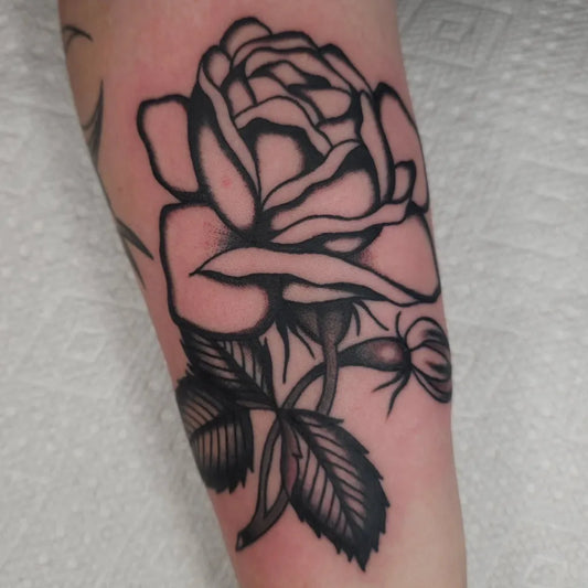Big Traditional Rose Bud Leaves on Women Arm Tattoo by @charietattoos