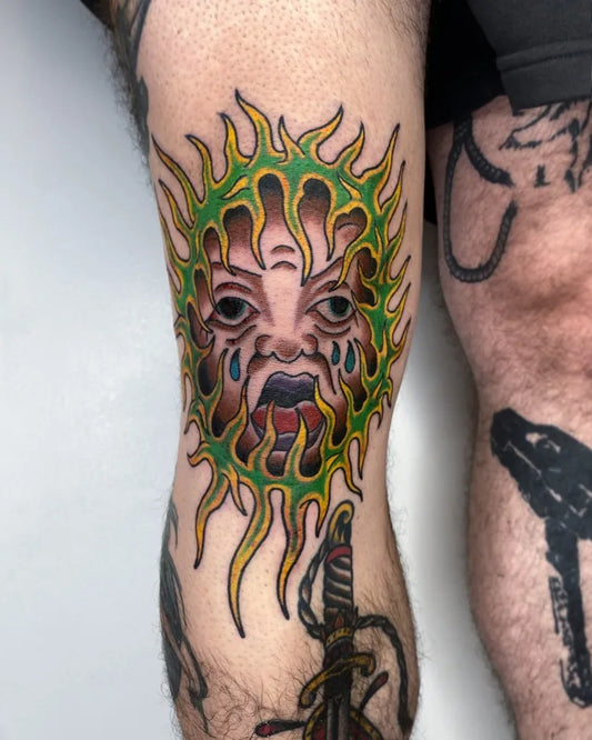 Big Traditional Sun Face Tattoo on Men Knee by @wastedyouth.tattooer