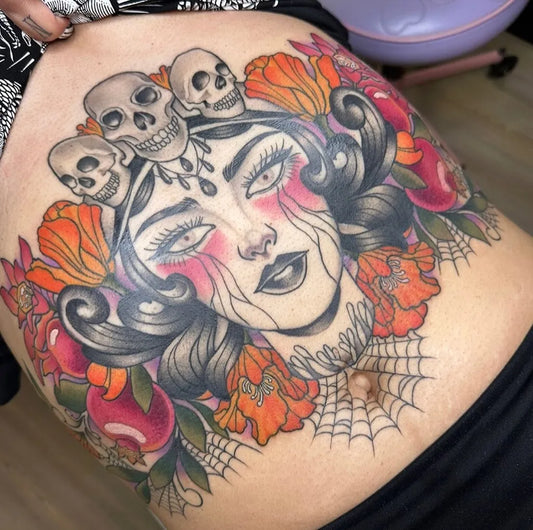 Big Traditional Womans Face with Skulls and Flowers Tattoo on Women Stomach by @sleepygaltattoos