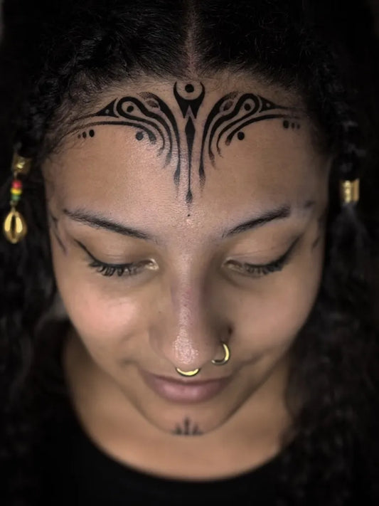 Big Tribal Symmetrical Forehead Design on Women Face Tattoo by @enola_tattoo
