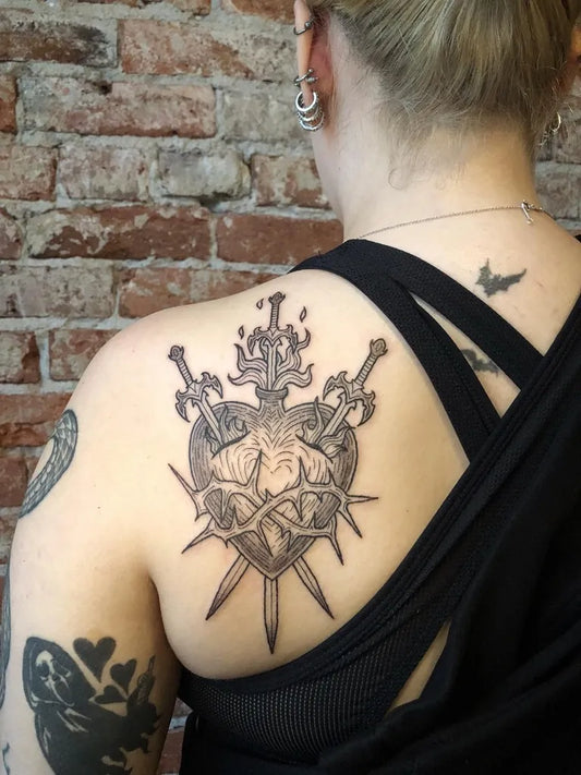 Big Woodcut Sacred Heart with Swords Tattoo on Women Shoulder by @lines.and.lore