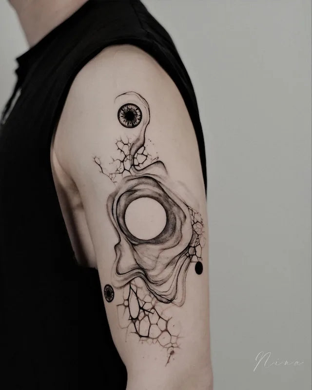 abstract black watercolor brush stroke circles tattoo on man upper arm