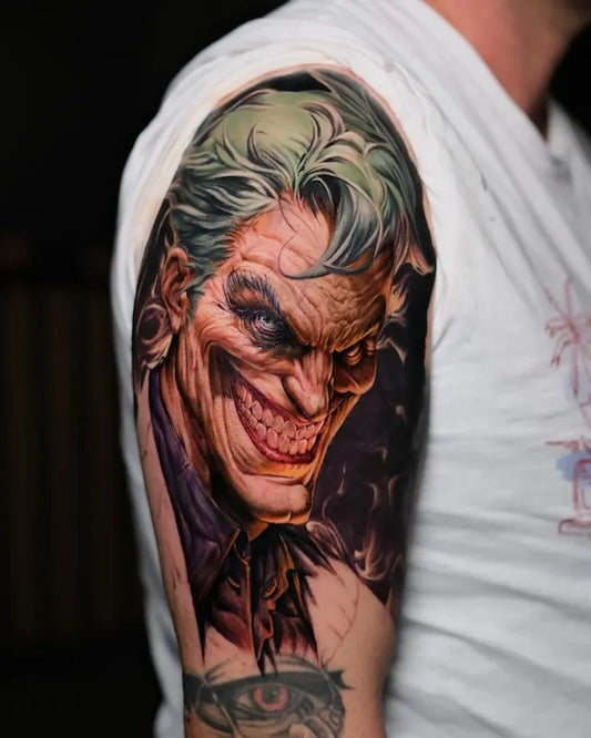 green hair joker portrait color realism tattoo on man upper arm