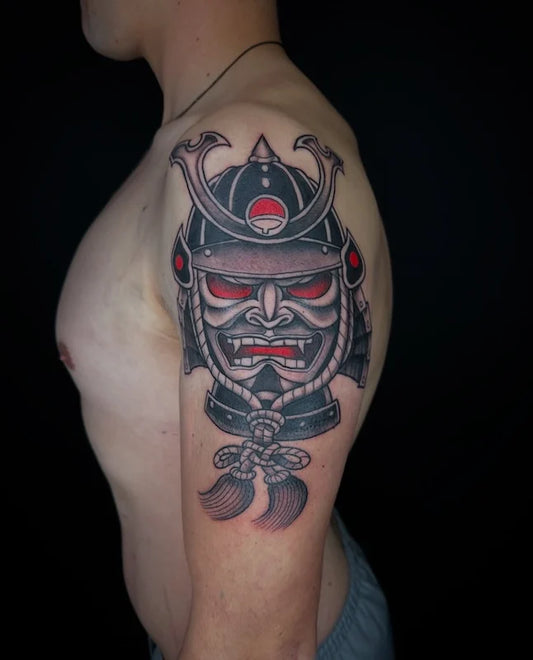 black and red tattoo of a samurai helmet on man upper arm