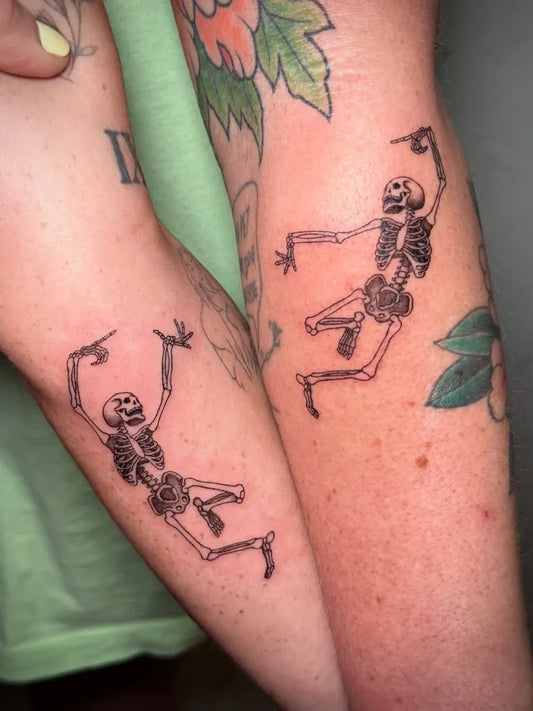 Matching Blackwork Skeleton Dance Tattoo on Women Arm by @amymarumoto.ink