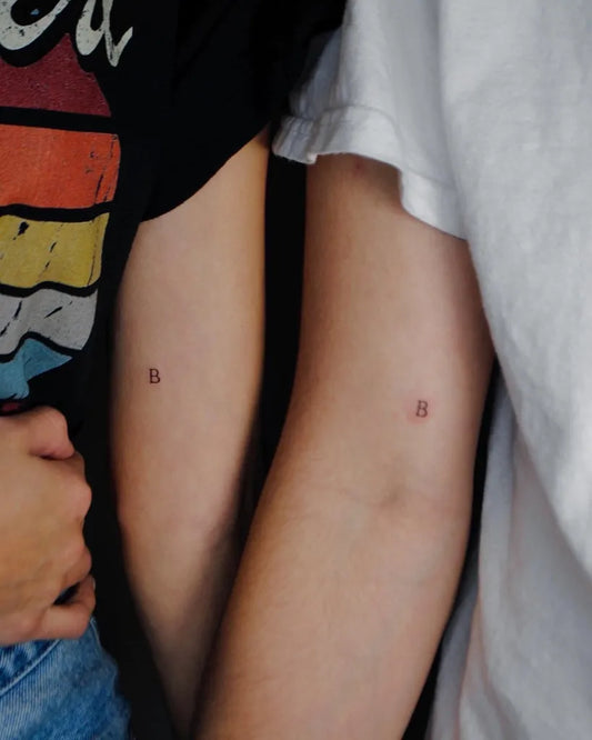 Matching Tiny Minimalist Letter B Tattoo on Women Bicep by @sincerelybriget