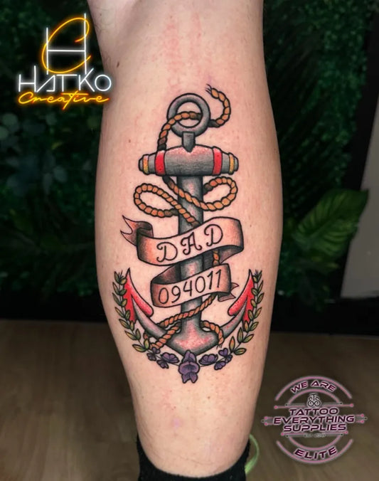 Medium American Traditional Anchor with Ribbon and Laurel Tattoo on Men Leg by @dannyscotttattooartist