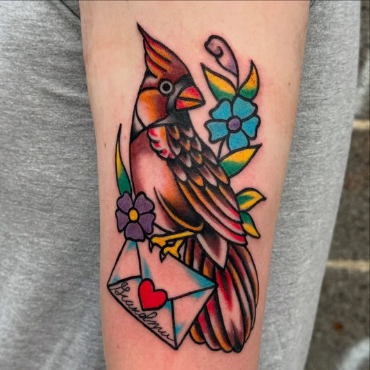 Medium American Traditional Cardinal with Letter and Flowers Tattoo on Women Arm by @ryanmachadotattoos