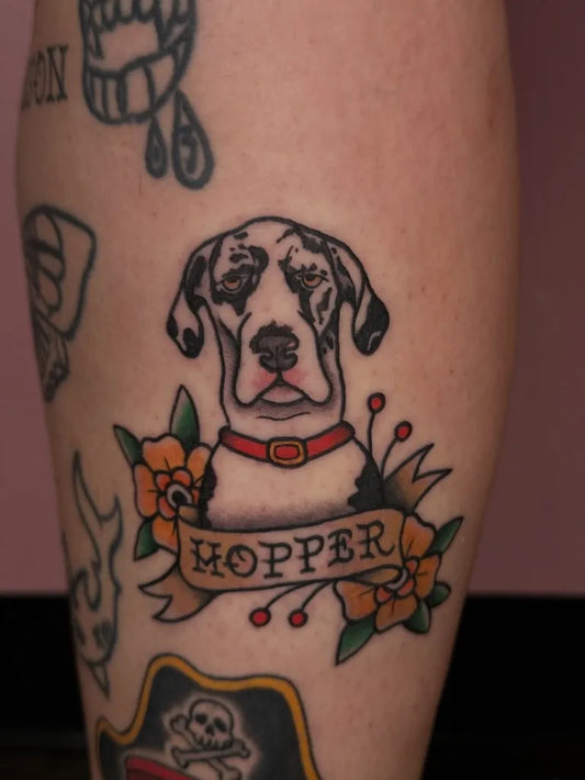 Medium American Traditional Dog with Banner and Flowers Tattoo on Women Leg by @inkedbyjoie