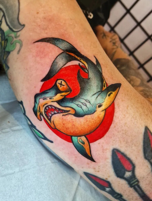 Medium American Traditional Great White Shark Biting Donut on Men Arm Tattoo by @thebrokenpuppet