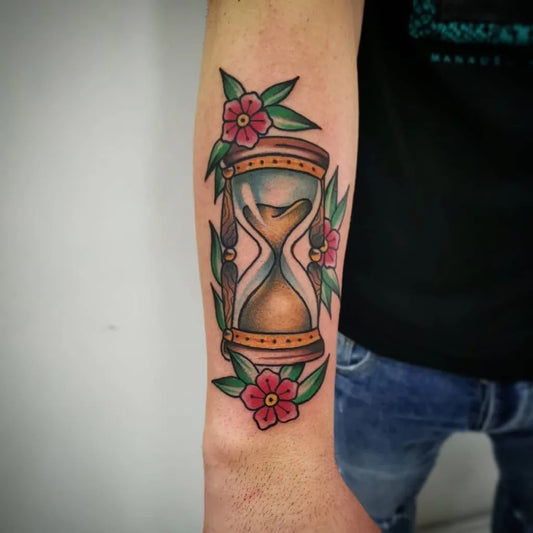 Medium American Traditional Hourglass and Flowers Tattoo on Men Arm by @love_mama_tattoo