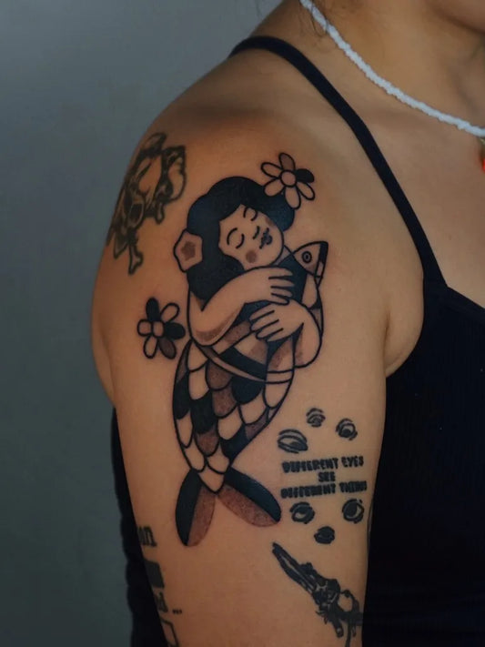 Medium American Traditional Mermaid with Fish Tattoo on Women Shoulder by @figtree.tattoo.studio