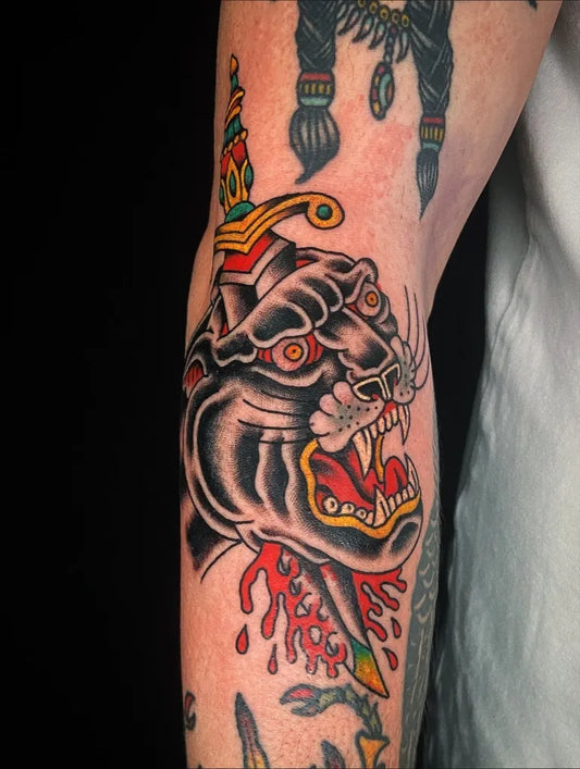 Medium American Traditional Panther with Dagger Tattoo on Men Arm by @junkatattoo