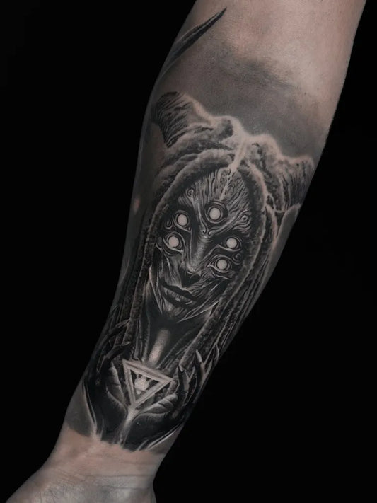 Medium Black and Grey Alien Face with Triangular Crystal Tattoo on Women Arm by @chucks_ink
