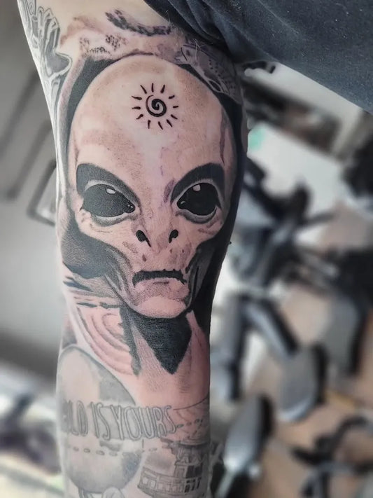 Medium Black and Grey Alien Skull Tattoo on Men Thigh by @wickermantattoo