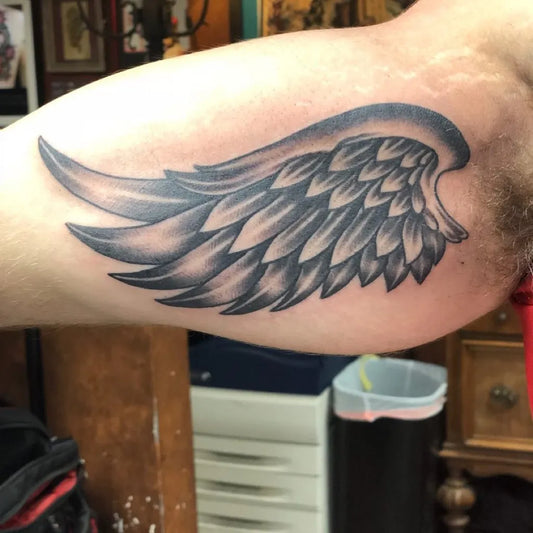 Medium Black and Grey Angel Wing Tattoo on Men Bicep by @woody_upinarms