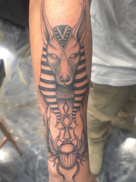 Medium Black and Grey Anubis Ankh Scarab Tattoo on Men Arm by @tattoos_bytrinity