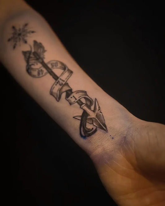 Medium Black and Grey Arrow with Banner and Snowflake Tattoo on Women Arm by @lynethy.tattoo