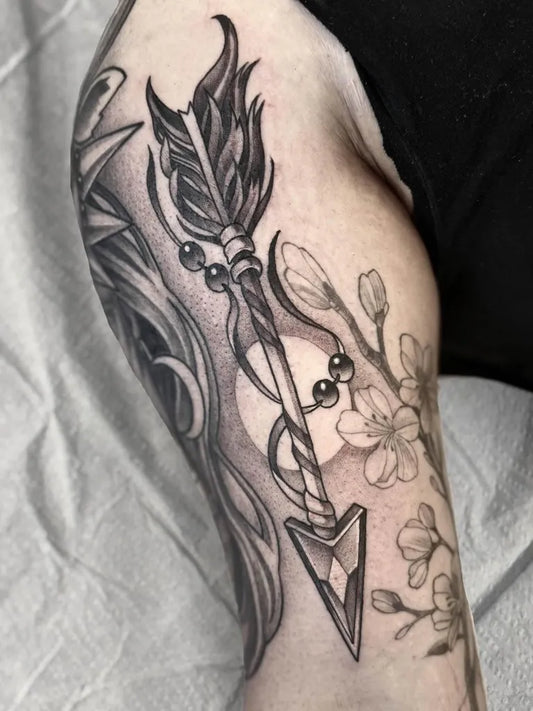 Medium Black and Grey Arrow with Cherry Blossoms Tattoo on Women Arm by @delicecastattoo