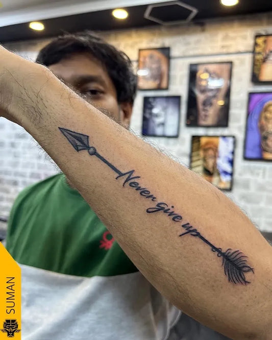 Medium Black and Grey Arrow with Never Give Up Text Tattoo on Men Arm by @mutants_tattoo_studio