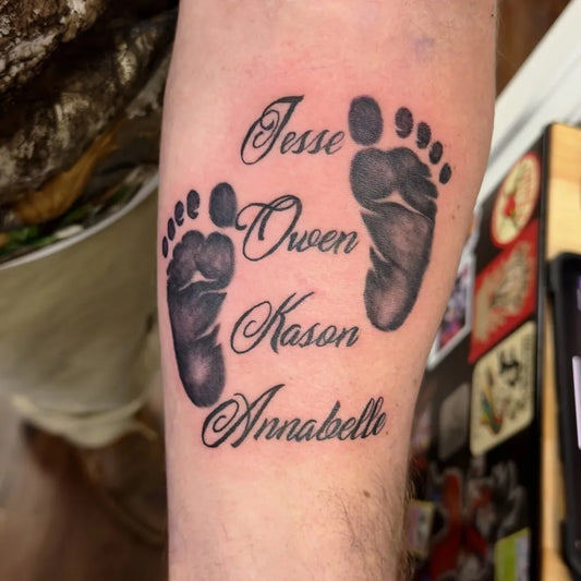 Medium Black and Grey Baby Footprints and Names Family Tattoo on Men Arm by @eleganceworc