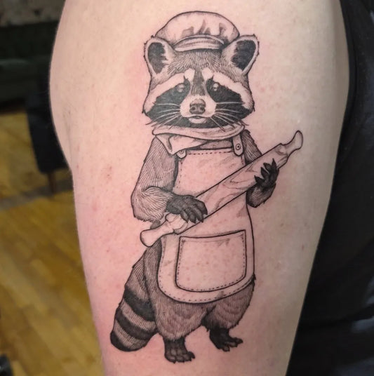 Medium Black and Grey Baking Raccoon Tattoo on Men Arm by @cbriggstattoo