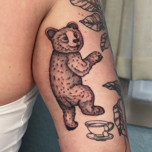 Medium Black and Grey Bear Teacup on Women Arm Tattoo by @laurenbolesart
