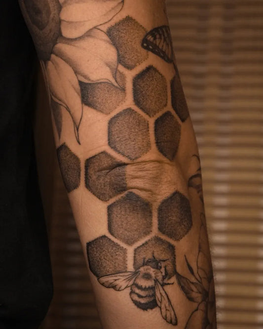 Medium Black and Grey Bee Flowers Honeycomb on Women Arm Tattoo by @lucid.invitation