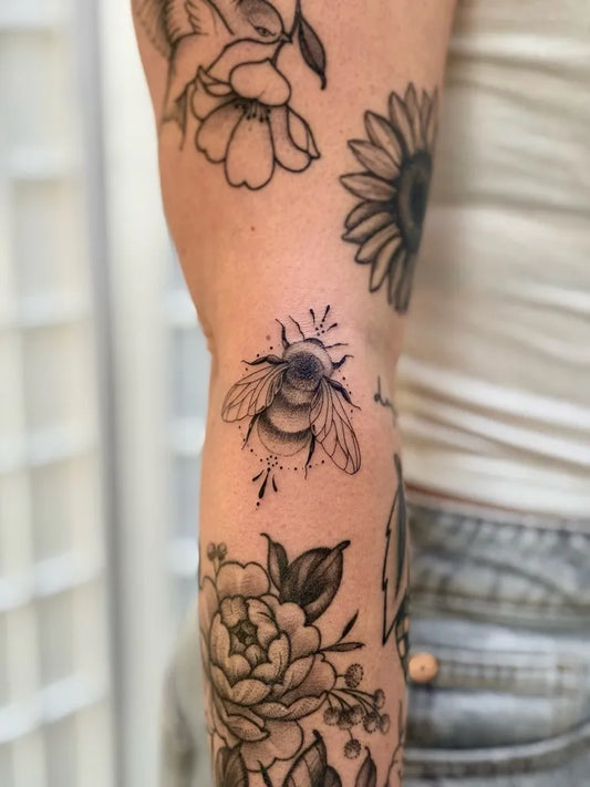 Medium Black and Grey Bee Flowers on Women Arm Tattoo by @laurensmithtattoos