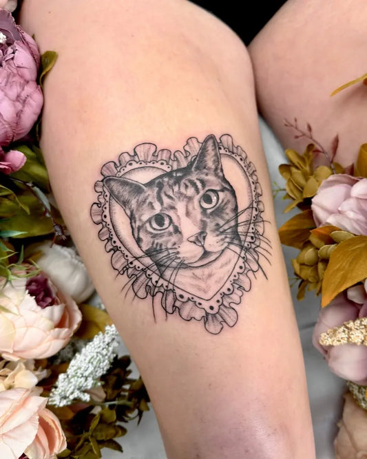 Medium Black and Grey Cat in Heart with Flowers Tattoo on Women Thigh by @miss.saskiatattoo