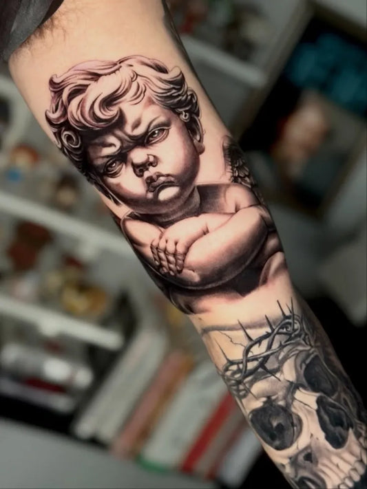 Medium Black and Grey Cherub and Skull Tattoo on Men Arm by @tattoodors